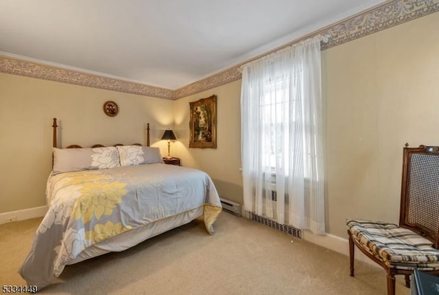 bedroom with crown molding, light colored carpet, and a baseboard heating unit