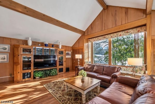 living room featuring vaulted ceiling with beams and hardwood / wood-style flooring