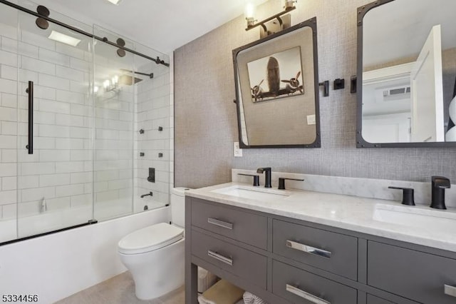 full bathroom featuring toilet, vanity, and shower / bath combination with glass door