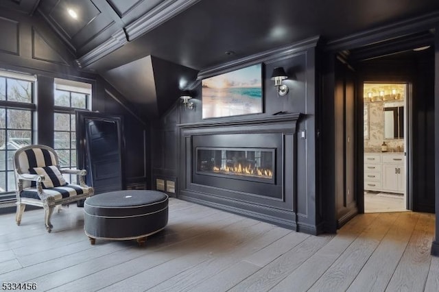 home theater room featuring light hardwood / wood-style flooring and vaulted ceiling