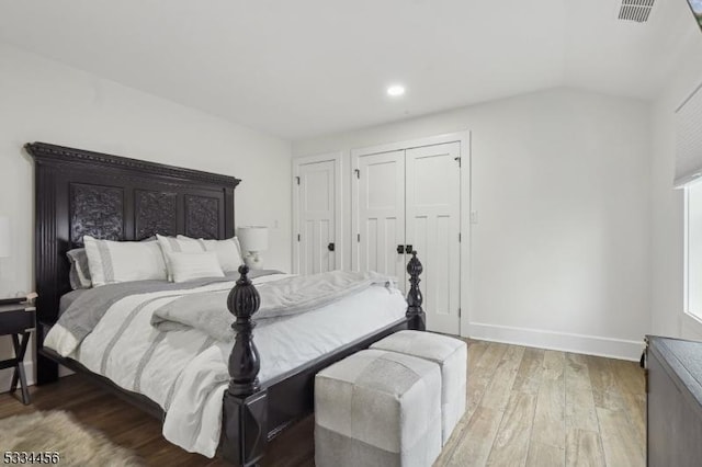 bedroom with lofted ceiling and wood-type flooring