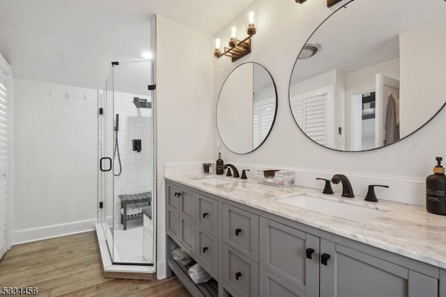 bathroom featuring hardwood / wood-style flooring, vanity, and a shower with shower door