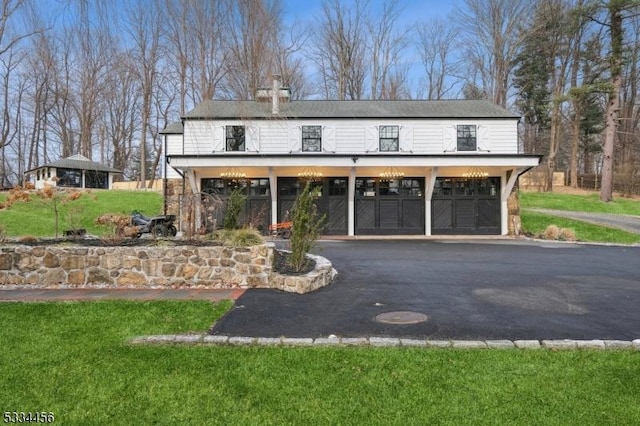 view of front of property featuring a garage and a front lawn