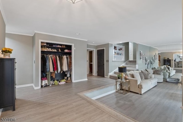 living room featuring hardwood / wood-style floors, crown molding, and built in shelves