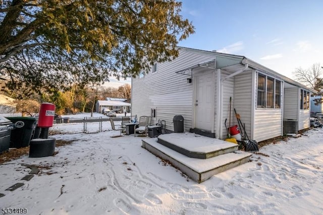 view of snow covered rear of property