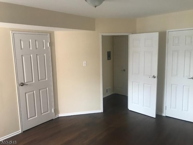 unfurnished bedroom with dark hardwood / wood-style flooring