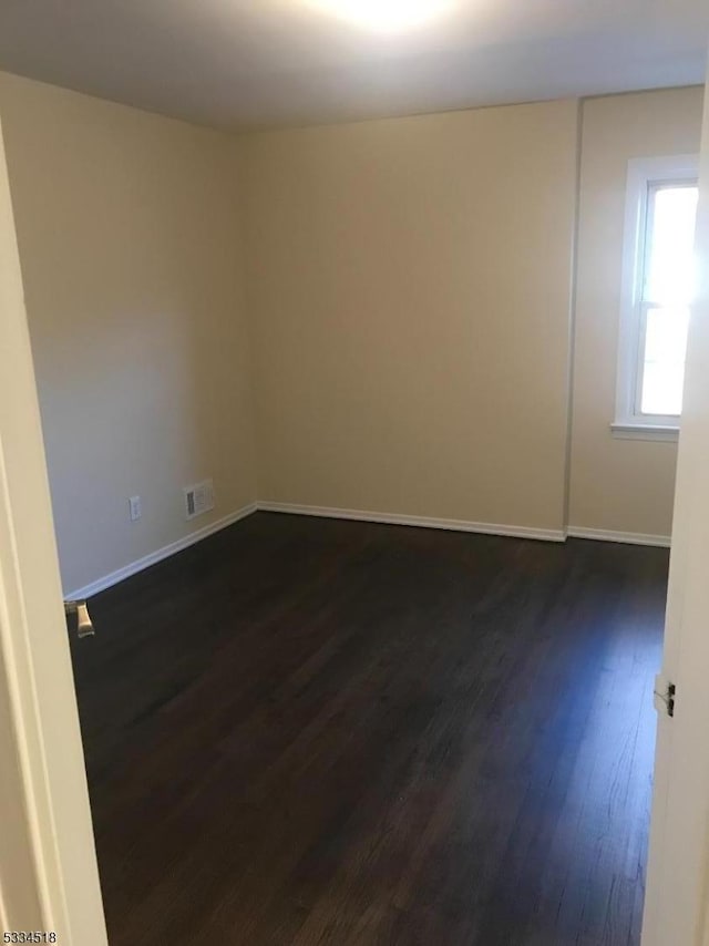 unfurnished room with dark hardwood / wood-style floors