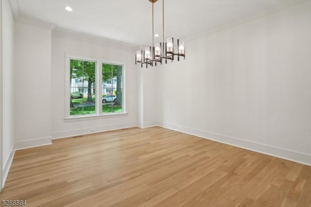 unfurnished dining area featuring crown molding, an inviting chandelier, and light hardwood / wood-style floors