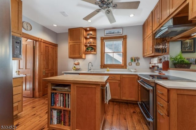 kitchen featuring butcher block countertops, sink, light hardwood / wood-style floors, stainless steel electric range oven, and built in microwave