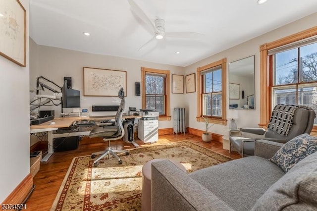 office with radiator, hardwood / wood-style floors, and ceiling fan