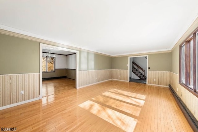 spare room with crown molding, hardwood / wood-style floors, and a baseboard radiator