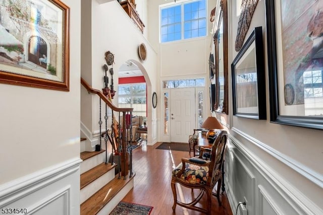 foyer with wood-type flooring and a towering ceiling