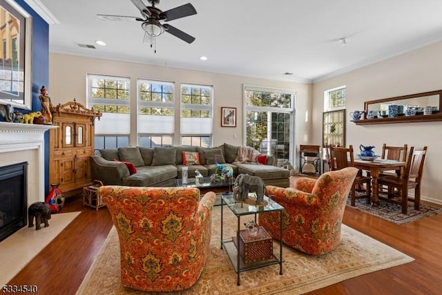 living room with ceiling fan, ornamental molding, dark hardwood / wood-style floors, and a wealth of natural light