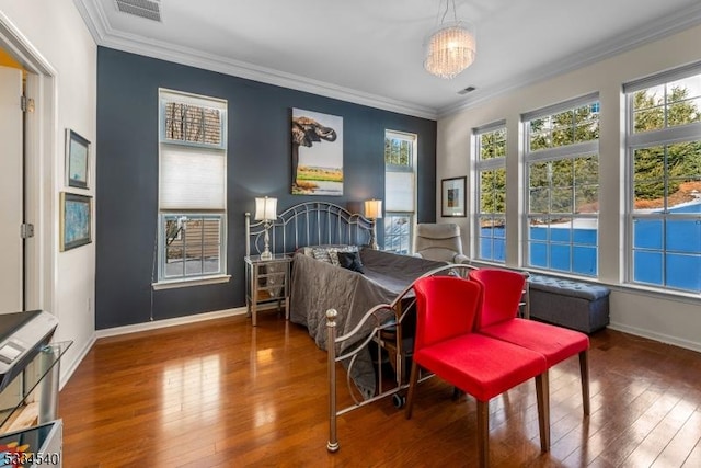 bedroom with ornamental molding, a chandelier, and hardwood / wood-style floors