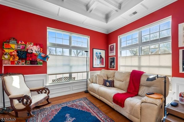 living area with ornamental molding, coffered ceiling, a wealth of natural light, and beam ceiling