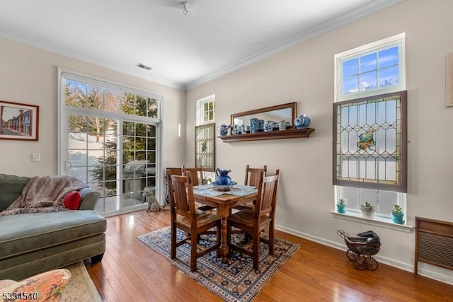 dining room featuring crown molding and light hardwood / wood-style flooring