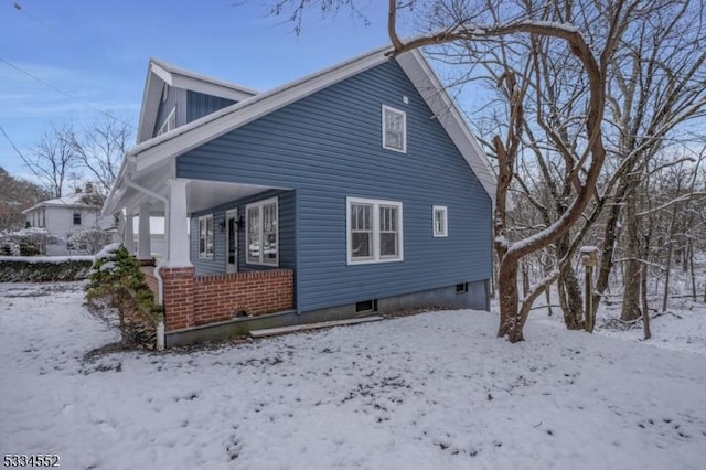 snow covered property with a porch