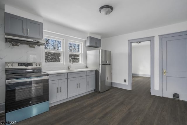 kitchen featuring stainless steel appliances, sink, dark hardwood / wood-style flooring, and gray cabinets