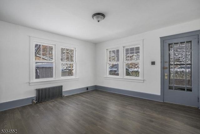 unfurnished dining area with dark wood-type flooring and radiator heating unit