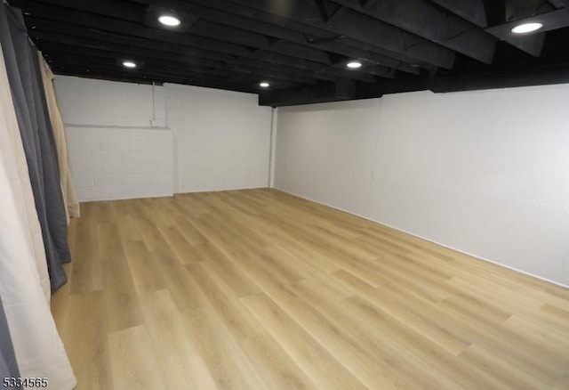 basement with light hardwood / wood-style flooring