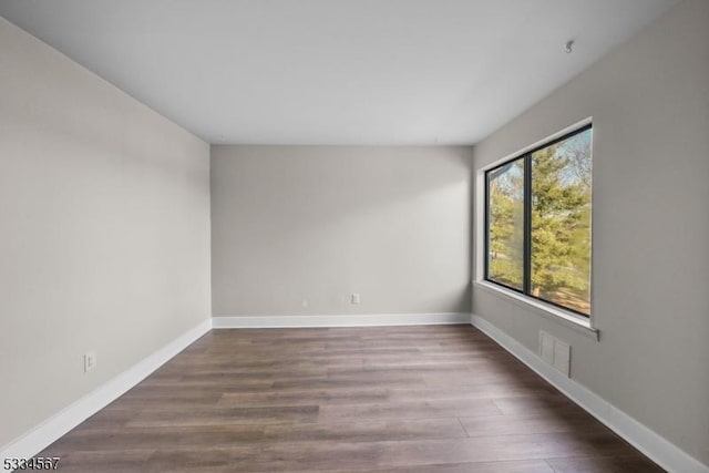 spare room featuring dark hardwood / wood-style flooring