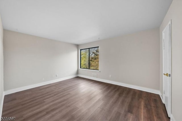 unfurnished room featuring dark hardwood / wood-style flooring