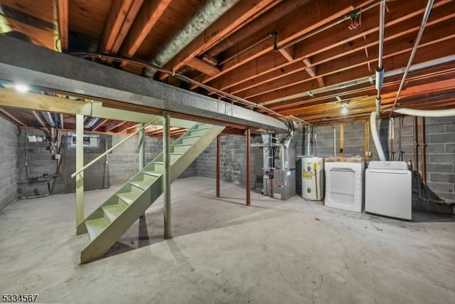 basement featuring heating unit, washer and clothes dryer, and water heater