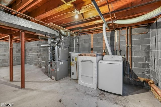 basement featuring heating unit, washing machine and clothes dryer, and water heater