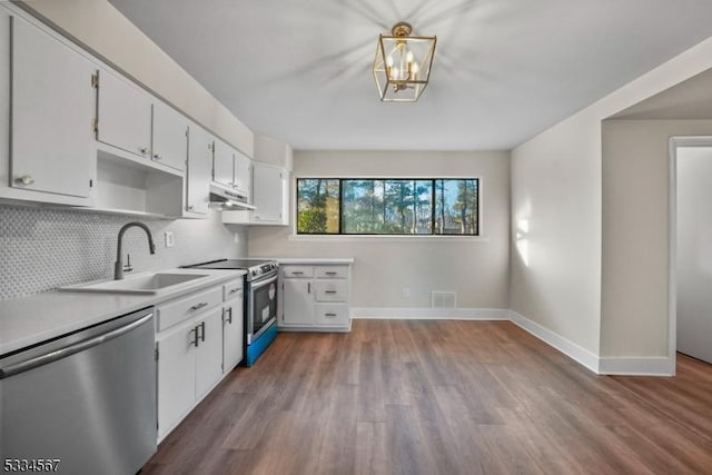 kitchen featuring pendant lighting, sink, white cabinetry, stainless steel appliances, and tasteful backsplash