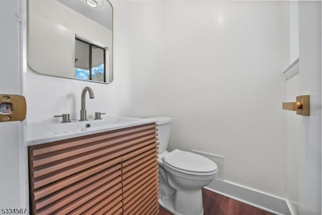 bathroom with hardwood / wood-style flooring, vanity, and toilet