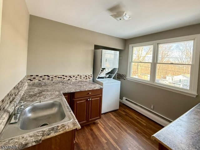 clothes washing area with cabinets, a baseboard radiator, dark hardwood / wood-style floors, and sink