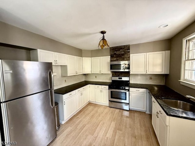 kitchen featuring sink, light hardwood / wood-style flooring, stainless steel appliances, and white cabinets