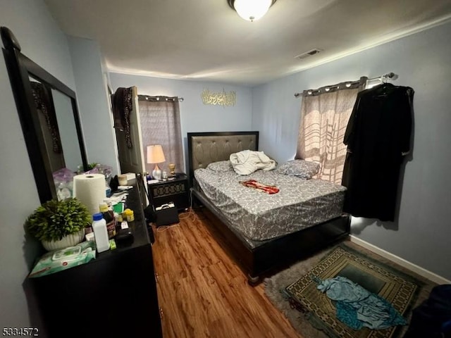 bedroom with wood finished floors and baseboards