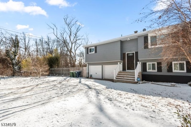 snow covered property with a garage