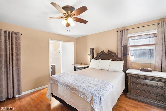 bedroom with ceiling fan, light wood-type flooring, and ensuite bath