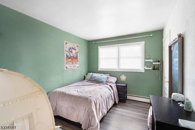 bedroom featuring a baseboard radiator and hardwood / wood-style floors