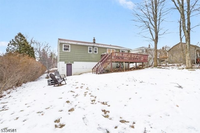 snow covered property featuring a wooden deck