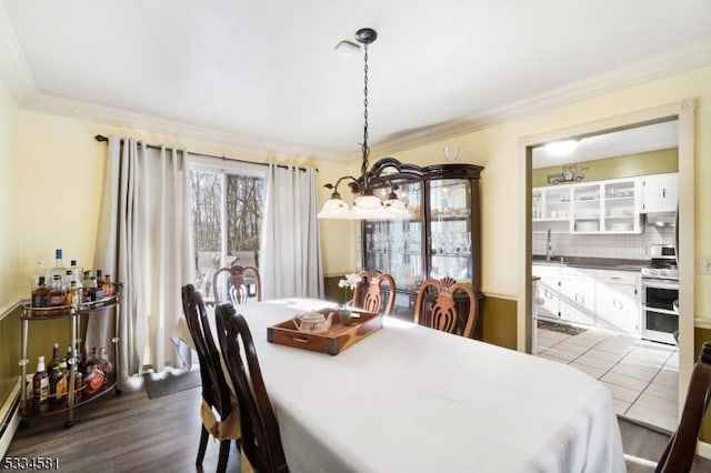 dining room with crown molding, dark hardwood / wood-style floors, a chandelier, and sink