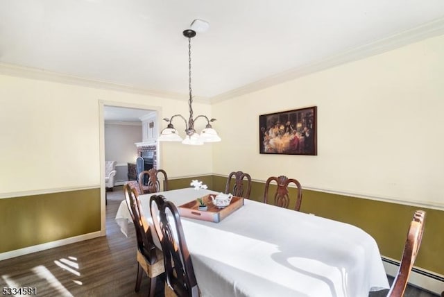 dining area with crown molding, dark hardwood / wood-style flooring, and a baseboard heating unit