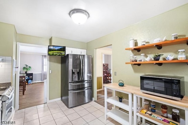 kitchen with white cabinetry, appliances with stainless steel finishes, and light tile patterned flooring