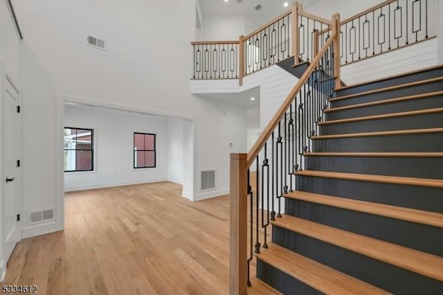 stairway with a high ceiling and hardwood / wood-style floors