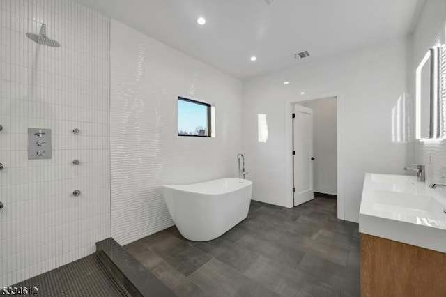 bathroom with vanity, shower with separate bathtub, and tile walls