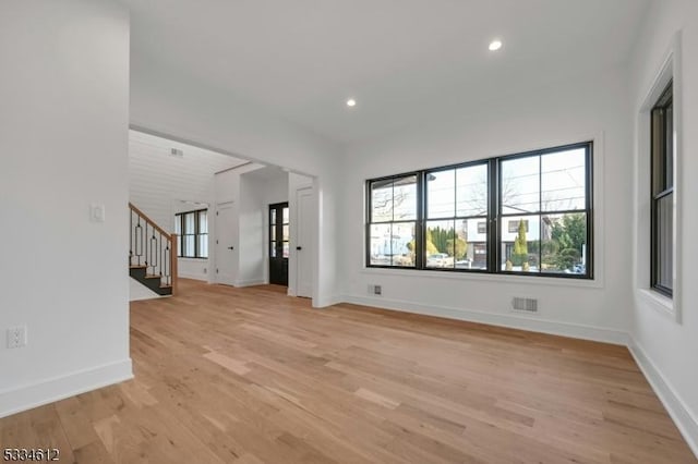 unfurnished living room with light hardwood / wood-style flooring and a wealth of natural light