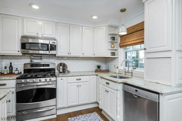 kitchen with white cabinetry, sink, hanging light fixtures, and appliances with stainless steel finishes