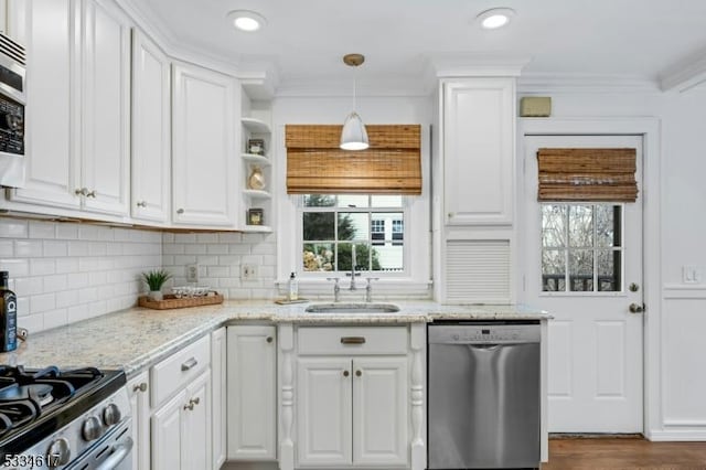 kitchen featuring white cabinetry, sink, stainless steel dishwasher, and light stone counters