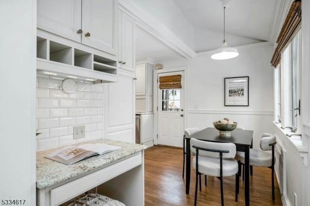 kitchen featuring white cabinetry, tasteful backsplash, light stone counters, decorative light fixtures, and dark hardwood / wood-style flooring