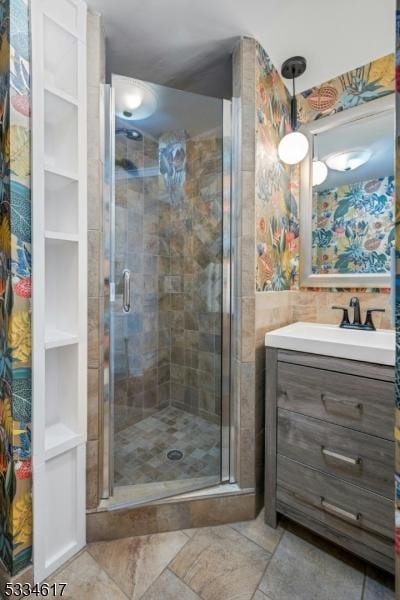 bathroom with vanity and a shower with door