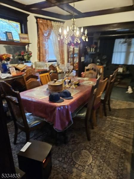 dining area with a notable chandelier and beam ceiling