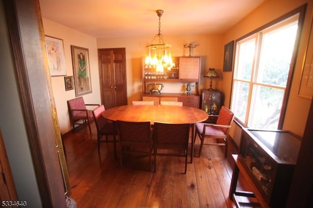 dining room featuring dark wood-type flooring and an inviting chandelier