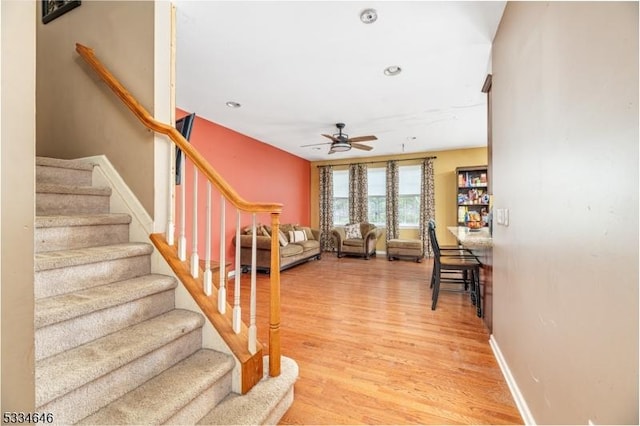 stairway featuring wood-type flooring and ceiling fan